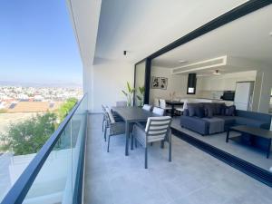 Phaedrus Living White Hills Suites Panoramic View في Aglantzia: غرفة طعام وغرفة معيشة مع طاولة وكراسي