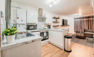 eine Küche mit Spüle und Arbeitsplatte in der Unterkunft Bright Cosy Cottage with Parking and Outdoor Patio in London