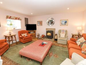 a living room with orange furniture and a fireplace at Todridge Barn in Newcastle upon Tyne