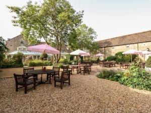 a patio with tables and chairs with umbrellas at Harley's House in Oakham
