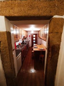 uma cozinha com armários de madeira e uma mesa em Casa Lopes no Alpalhão