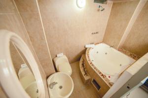 a bathroom with a tub and a toilet and a sink at Hotel Luxor Pucallpa in Pucallpa +19 photos