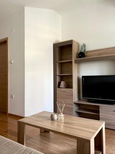 - un salon avec une table basse et une télévision à écran plat dans l'établissement Urban City Apartment, à Skopje