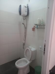 Villa Akela Sukabumi في سوكابومي: حمام مع مرحاض وهاتف على الحائط