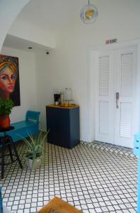 een kamer met een blauwe stoel en een schilderij aan de muur bij HOSTAL BOUTIQUE 53 in Santo Domingo