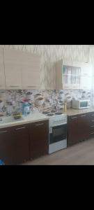 Il comprend une cuisine équipée d'une cuisinière et d'un comptoir. dans l'établissement ЖК КОРКЕМ ул. Мангилик ел 17, à Astana