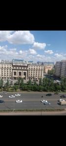 un grand bâtiment avec des voitures garées dans un parking dans l'établissement ЖК КОРКЕМ ул. Мангилик ел 17, à Astana