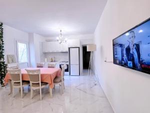 ein Esszimmer mit einem Tisch und einem TV an der Wand in der Unterkunft WSD Faliro New 1BD Apartment with Bal Near Alimos Marina in Athen