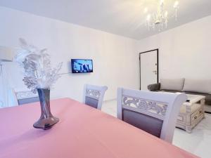 uma sala de jantar com uma mesa rosa e cadeiras em WSD Faliro New 1BD Apartment with Bal Near Alimos Marina em Atenas