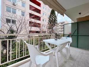 uma mesa branca e cadeiras numa varanda em WSD Faliro New 1BD Apartment with Bal Near Alimos Marina em Atenas