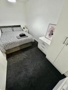 a bedroom with a bed and a dresser with a picture at Bradford Service accommodation in Bradford +9 photos