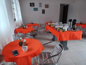 an empty restaurant with orange tables and chairs at Torre do Sol in Praia do Frances
