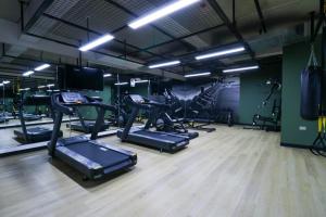 a gym with several treadmills and elliptical machines at Kennedy by Wynwood House in Lima