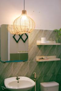 a bathroom with a sink and a chandelier at Vila Basi in Nguyệt Hạng