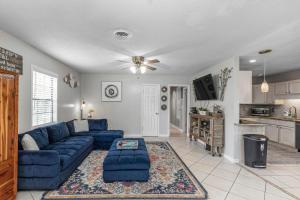 ein Wohnzimmer mit einem blauen Sofa und einer Küche in der Unterkunft Pickleball Pets Ping-Pong Fire Pit 2m to Beach in Fort Walton Beach