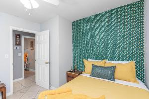 sypialnia z żółtym łóżkiem i niebieską ścianą w obiekcie Pickleball Pets Ping-Pong Fire Pit 2m to Beach w mieście Fort Walton Beach