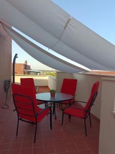 een patio met een tafel en stoelen op een dak bij Ático Mirabal in Mairena del Aljarafe