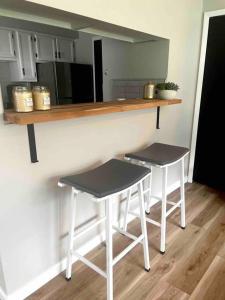 a kitchen with two stools and a counter in a room at New Stylish Condo Monthly Rental 