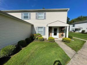 a white house with a grass yard at New Stylish Condo Monthly Rental in Reminderville