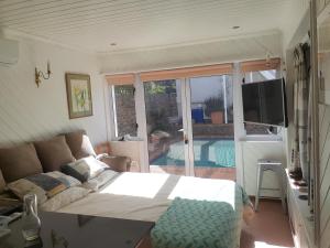 uma sala de estar com uma cama, uma televisão e um sofá em Karsen residence em Cidade do Cabo