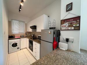 una cocina con nevera y lavadora en Casa Del Sol Townhouse in Iris Village Paphos, en Pafos 58 fotos más