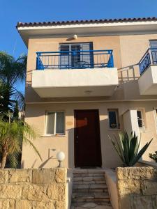 Casa Del Sol Townhouse in Iris Village Paphos في بافوس: منزل فيه باب وبلكونه