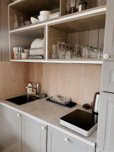 a kitchen with white cabinets and a counter top at HYGGE Sauna&Fishing House in Jagėlonys Kalniniai