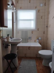 een badkamer met een bad, een wastafel en een toilet bij En el Parque de las Meanas. in Avilés
