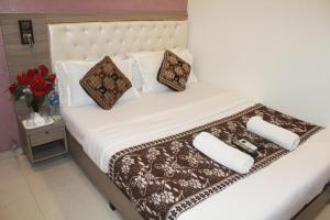Una cama blanca con dos almohadas encima. en Hotel Golden Arch - NEAR DOMESTIC AIRPORT, en Bombay