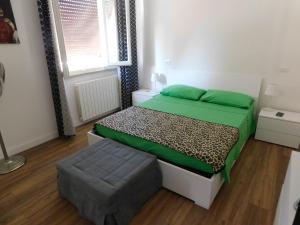 ein kleines Schlafzimmer mit einem Bett und einer Ottomane in der Unterkunft Versilia Tonfano villetta in Marina di Pietrasanta