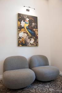 due sedie in una stanza con un dipinto sul muro di Jensen Luxury Suites a Città di Rodi