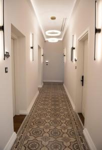 um corredor vazio com piso em azulejo e paredes brancas em Jensen Luxury Suites in Ilha de Rhodes
