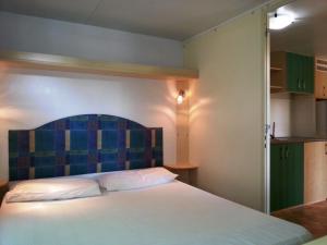 a bedroom with a large bed with a blue headboard at Villaggio Camping Europa in Sottomarina