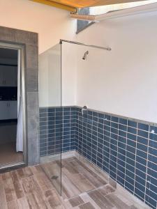 a bathroom with a glass shower with blue tiles at COSTA AZUL APARTMENTS - 1C in Puerto de Mogán +23 photos