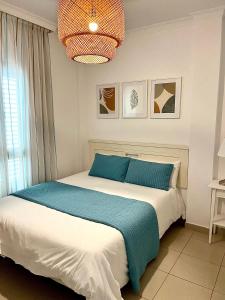 a bedroom with a bed and a chandelier at COSTA AZUL APARTMENTS - 1C in Puerto de Mogán