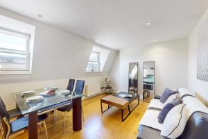 ein Wohnzimmer mit einem Sofa und einem Tisch in der Unterkunft Park Lane Apartments Marylebone in London