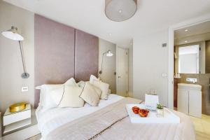 ein Schlafzimmer mit einem großen weißen Bett und einem Tablett mit Obst darauf in der Unterkunft Park Lane Apartments Marylebone in London