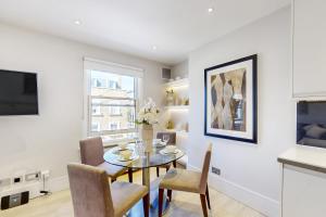 eine Küche und ein Esszimmer mit einem Tisch und Stühlen in der Unterkunft Park Lane Apartments Marylebone in London
