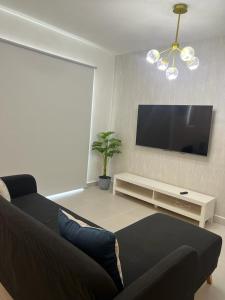 uma sala de estar com um sofá e uma televisão de ecrã plano em Sweet home em Punta Cana