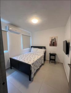 a bedroom with a bed and a television in it at Sweet home in Punta Cana