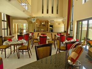 a restaurant with tables and chairs and a kitchen at Castellon Boutique Hotel in Table View