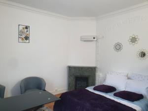 biała sypialnia z łóżkiem i krzesłem w obiekcie Studio/Bourget/CDG/Villepinte w mieście Aulnay-sous-Bois