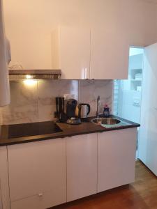 kuchnia z białymi szafkami i zlewem w obiekcie Studio/Bourget/CDG/Villepinte w mieście Aulnay-sous-Bois +7 zdjęć