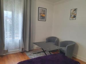 stół i 2 krzesła w pokoju z oknem w obiekcie Studio/Bourget/CDG/Villepinte w mieście Aulnay-sous-Bois