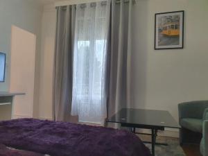 sypialnia z łóżkiem, stołem i oknem w obiekcie Studio/Bourget/CDG/Villepinte w mieście Aulnay-sous-Bois