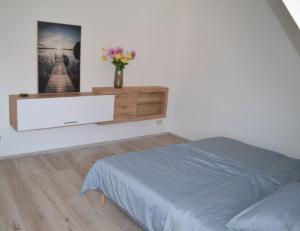 sypialnia z łóżkiem i wazonem z kwiatami w obiekcie Pension,Ferien, Monteurwohnung , Unterkunft,Zimmer w mieście Schönebeck