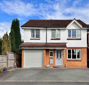 a white and red house with a garage at 4 Bedroom Contemporary Home in Hereford in Hereford