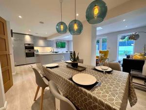ein Esszimmer und eine Küche mit einem Tisch und Stühlen in der Unterkunft 4 Bedroom Contemporary Home in Hereford in Hereford