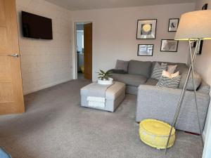 ein Wohnzimmer mit einem Sofa und einem TV in der Unterkunft 4 Bedroom Contemporary Home in Hereford in Hereford