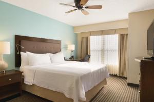 Homewood Suites Grand Rapids في غراند رابيدز: غرفة الفندق بسرير ومروحة سقف